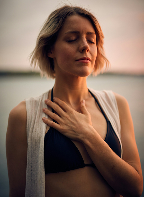 woman with eyes closed and hand over chest