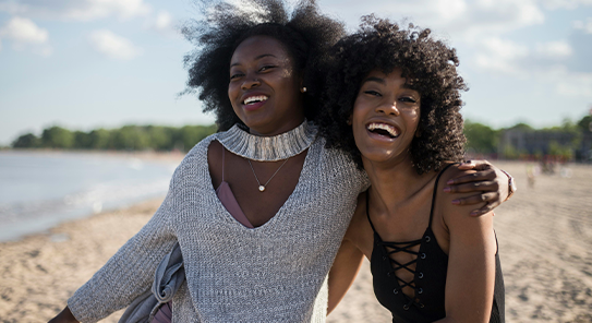 two women smiling on a beach