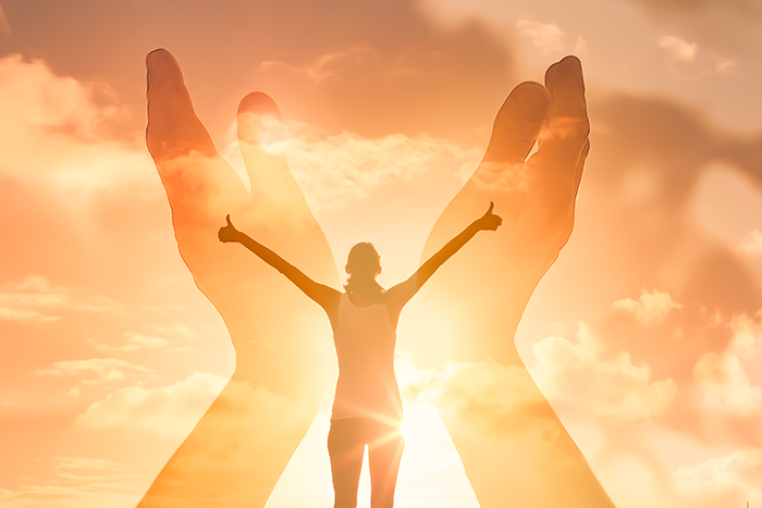 person with thumbs up standing in the sunlight